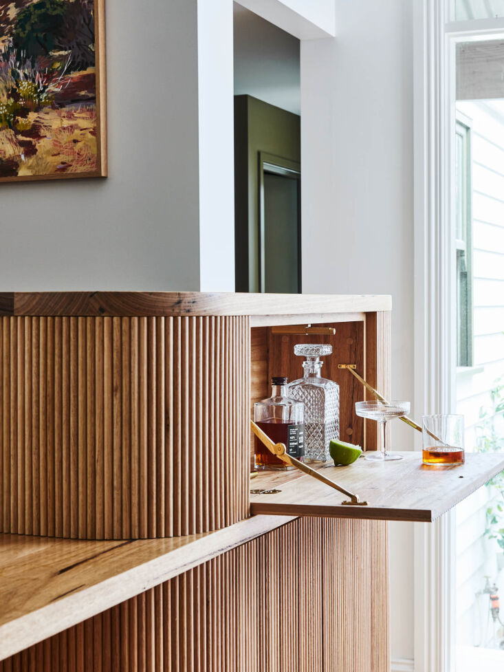 Open wooden cabinet revealing a concealed home bar and storage area.