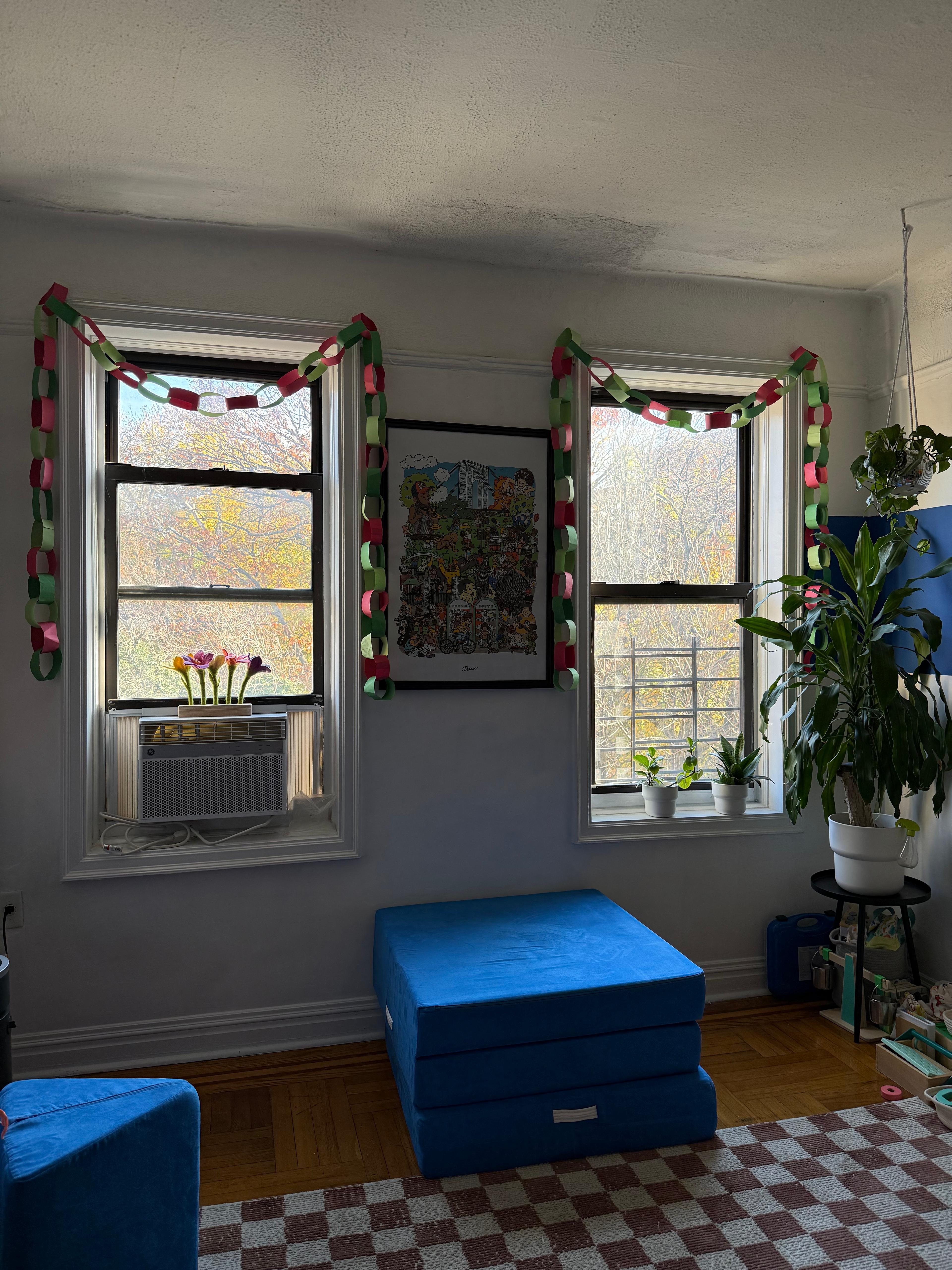 Festive Christmas greenery and ornaments arranged along a window sill with a view outside.