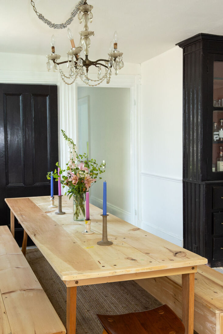 A simple dining set under a formal chandelier in a rental home.