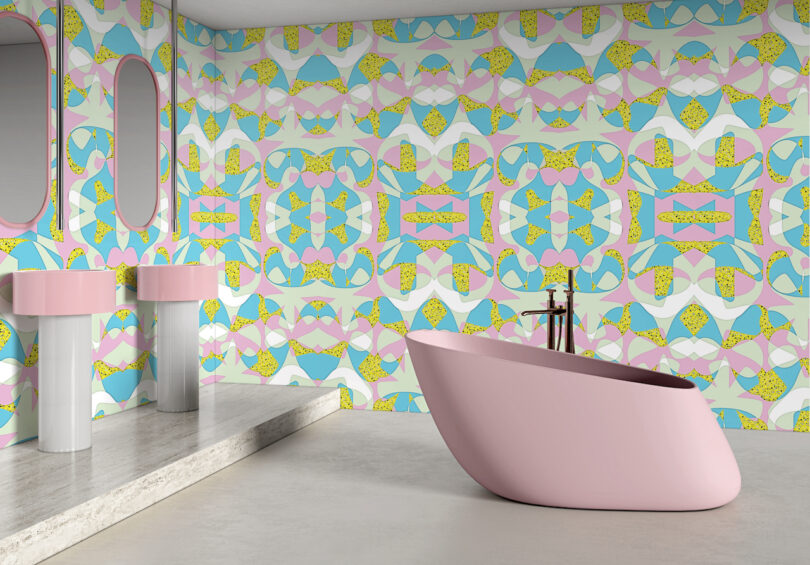 A pink bathroom featuring retro pastel geometric wallpaper in shades of pink, blue, and yellow.