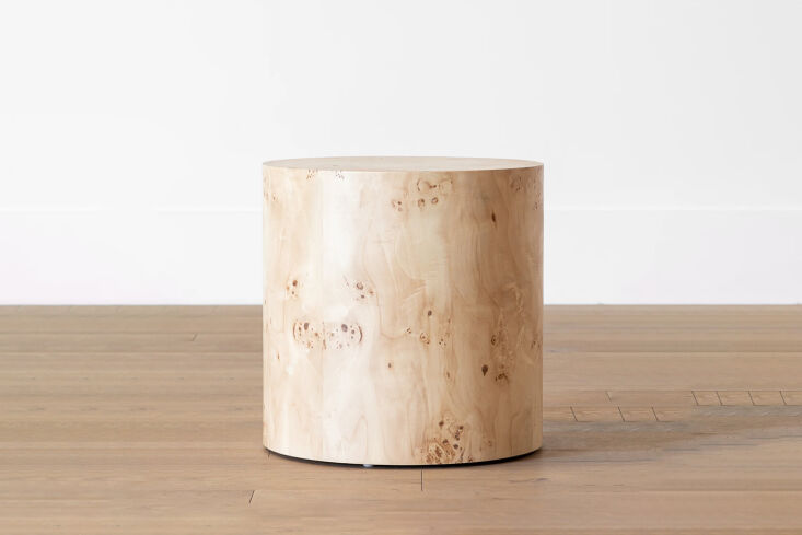 A cylindrical side table with a natural burl wood finish and visible organic wood knots.