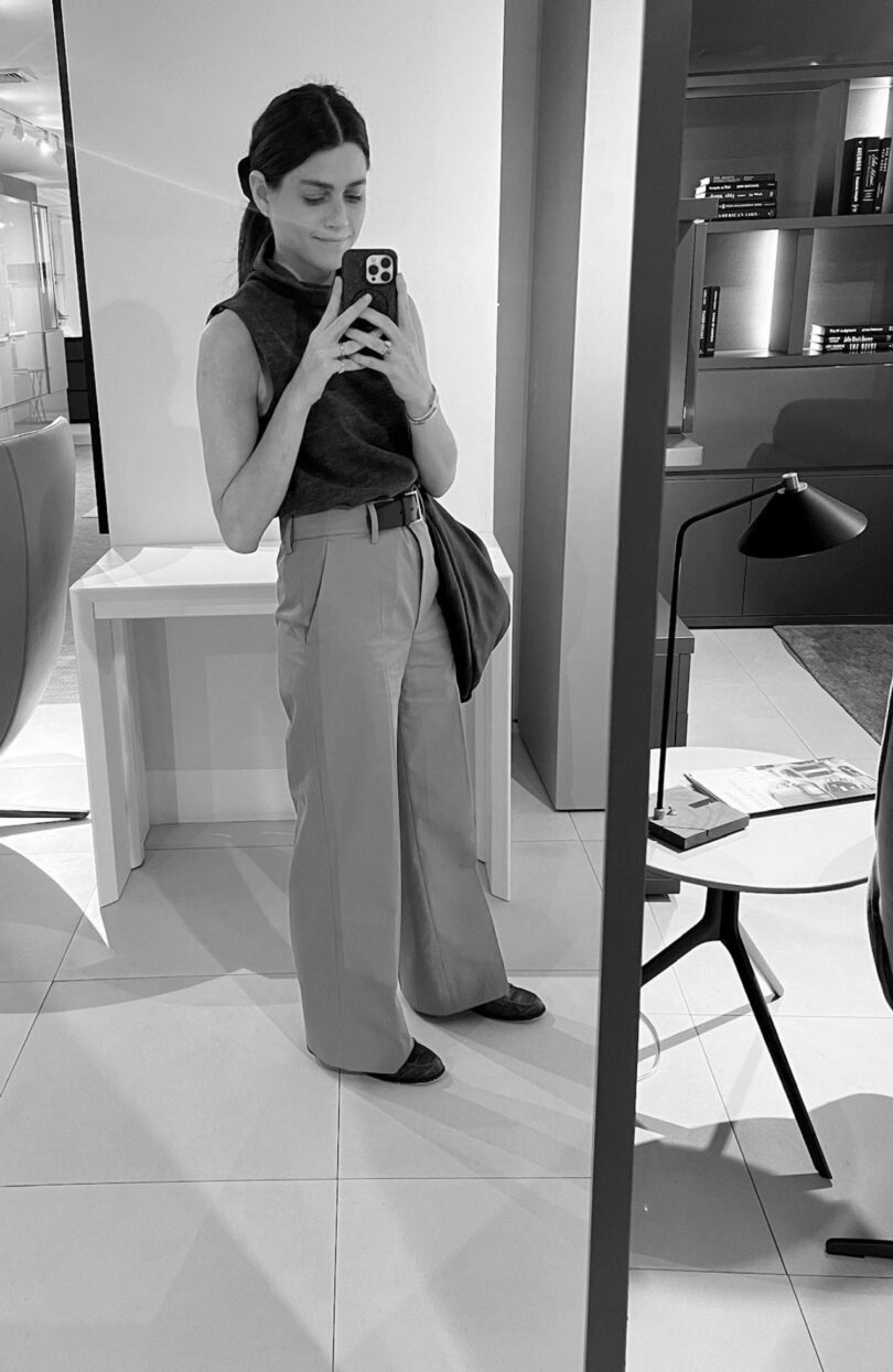 Architect Nicki Gitlin taking a mirror selfie in a minimalist, organized home office.