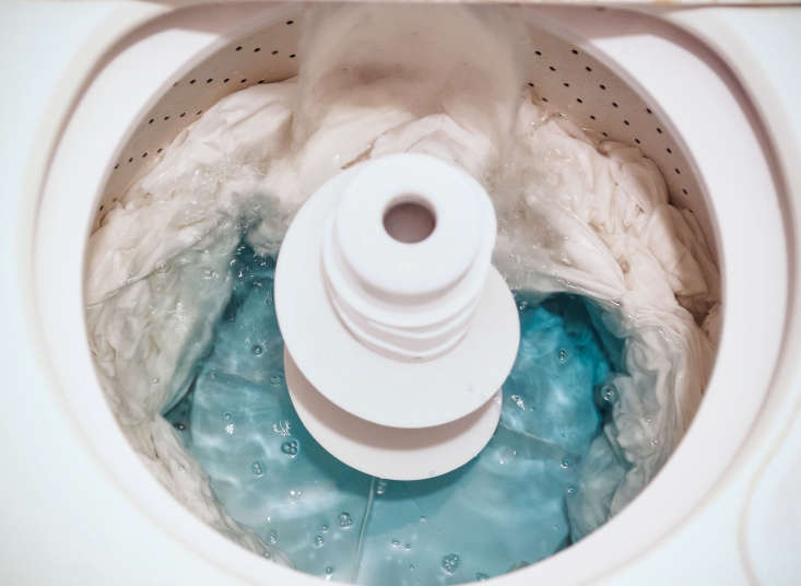 The drum of a top-loading washing machine filling with water before the bluing solution is added.