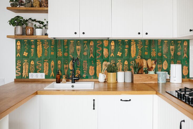 Green zellige tiles decorated with hand-painted gold and black glazes.