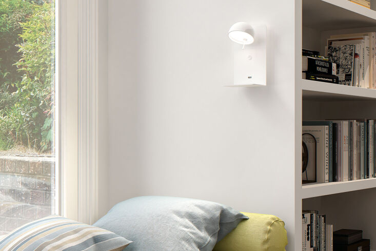 A high-end white wall lamp with an adjustable arm and integrated shelf.