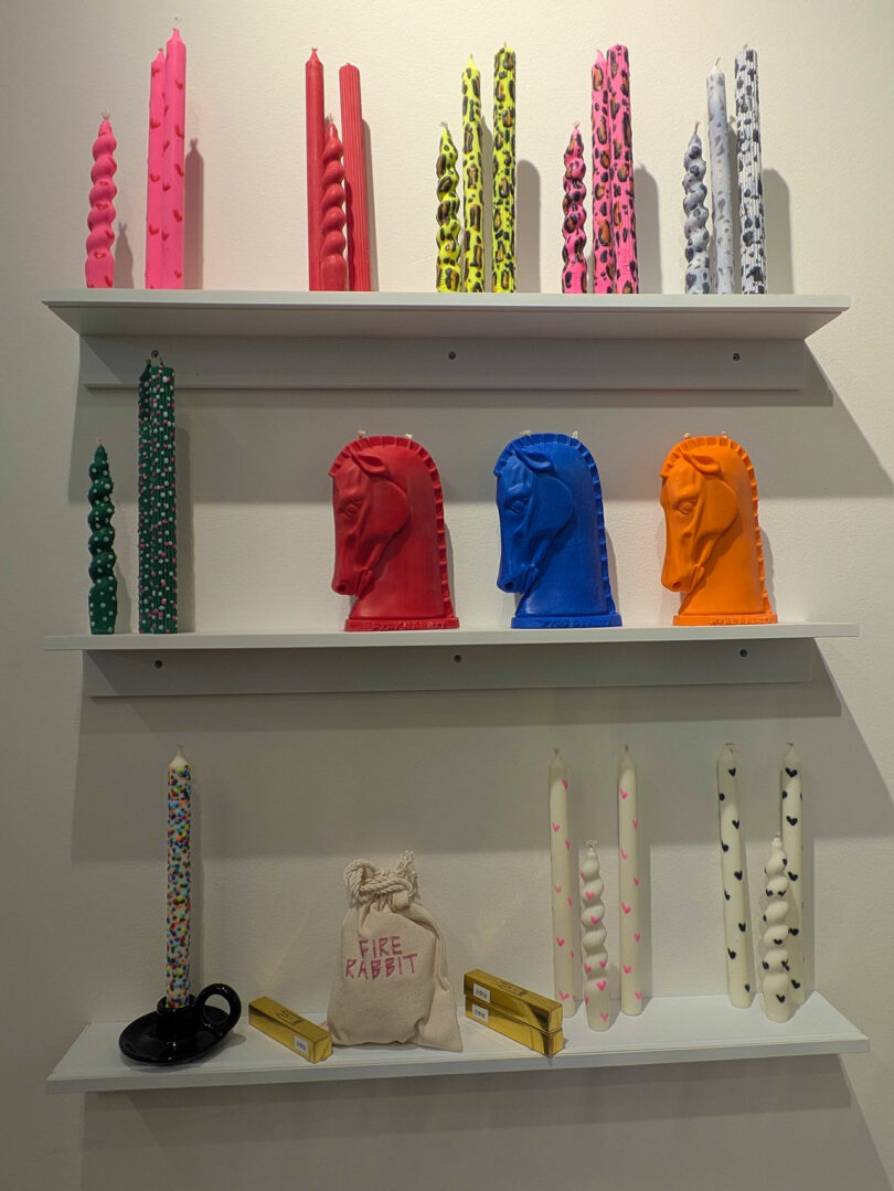 Artistic candles in unique shapes like twisted columns and knight heads on display.