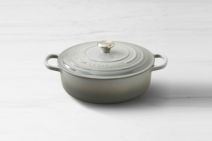 A classic orange Le Creuset Signature Enameled Cast Iron Round Wide Dutch Oven.