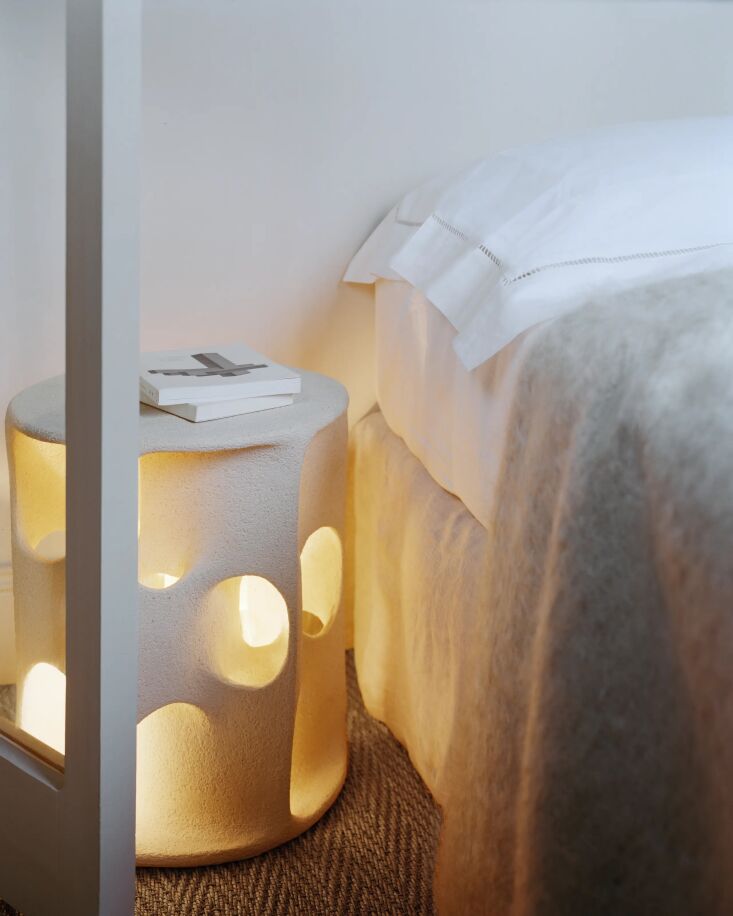 An illuminated side table on top of jute carpeting in a Parisian apartment.