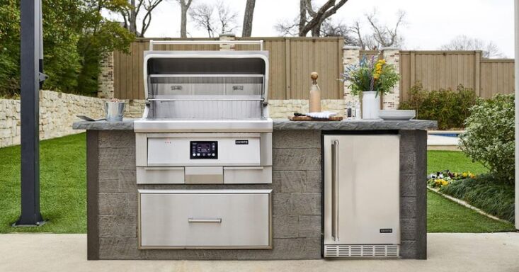 A compact and stylish outdoor kitchen with a built-in grill and minimalist cabinetry.