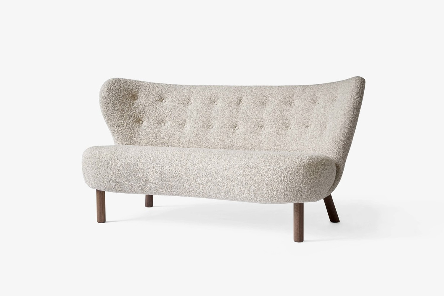 A Little Petra VB2 loveseat with soft white bouclé fabric and wooden legs.