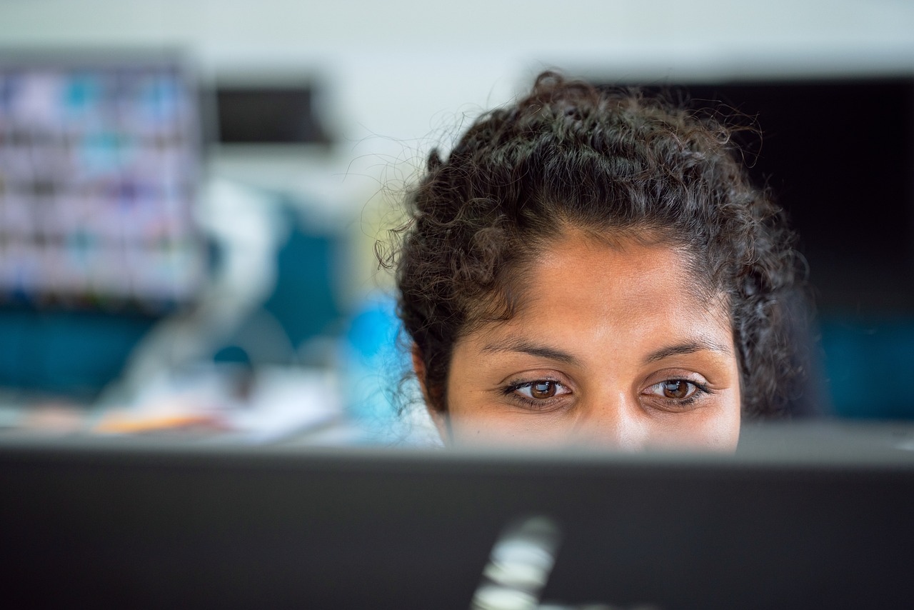 Close up of a person looking at a screen at a slight downward angle.