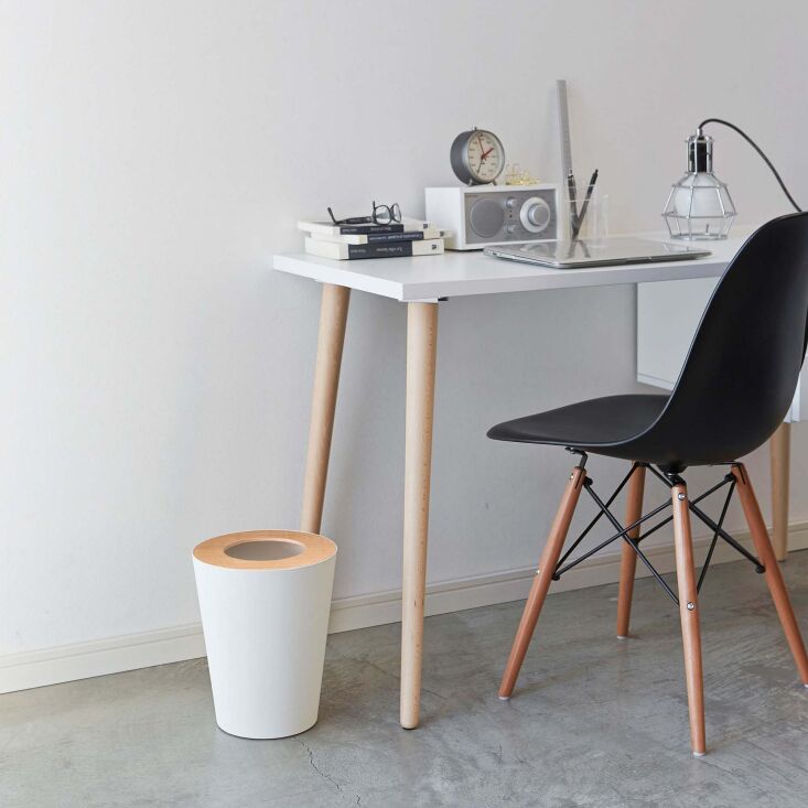 A minimalist white steel trash can featuring a natural walnut wood rim.