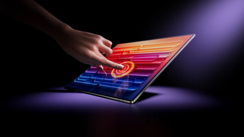 A hand interacting with a high-resolution touch-sensitive screen displaying vibrant colors.