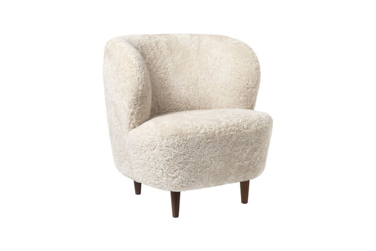 GUBI Stay Lounge Chair in white sheepskin with a continuous rounded back and base.