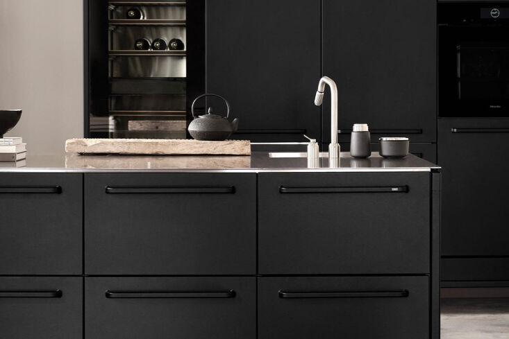 Vipp V1 modular kitchen modules with black cabinetry and integrated cooktop.
