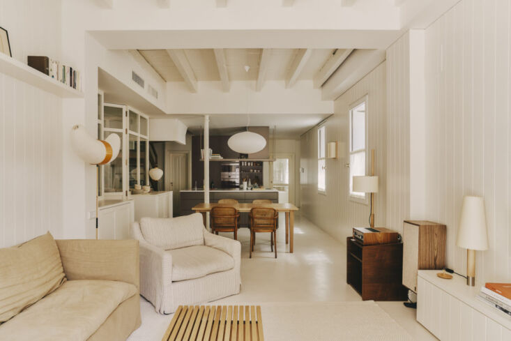 A Básica lamp sitting on a low wooden credenza in a modern living space.