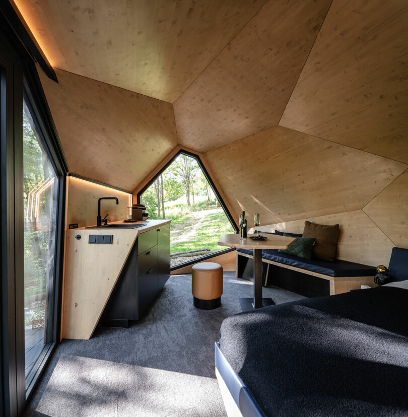Interior of a cabin featuring geometric wood paneling on the walls and ceiling.