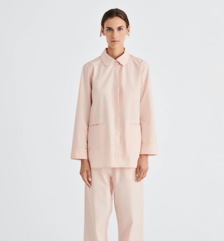 Two pairs of structured cotton pajamas in rose and charcoal grey, folded neatly to show French seams.
