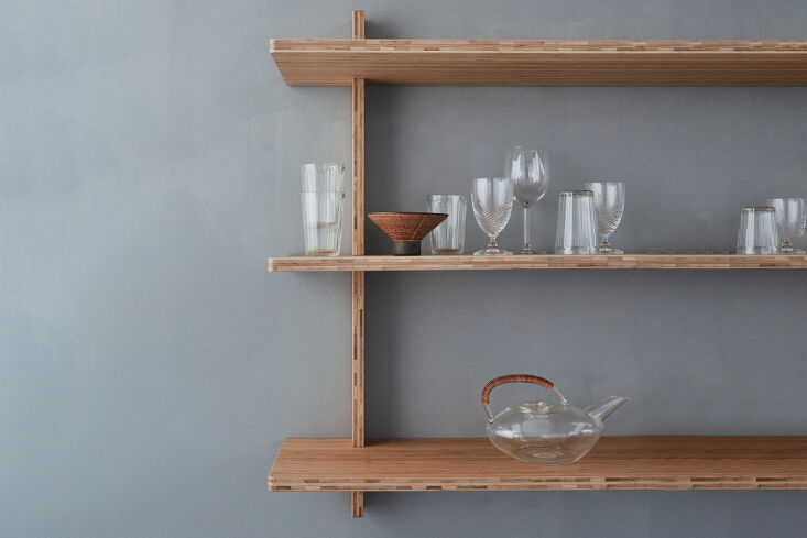 Minimalist A7 Cross Shelf in Rye finish bamboo mounted on a white wall.