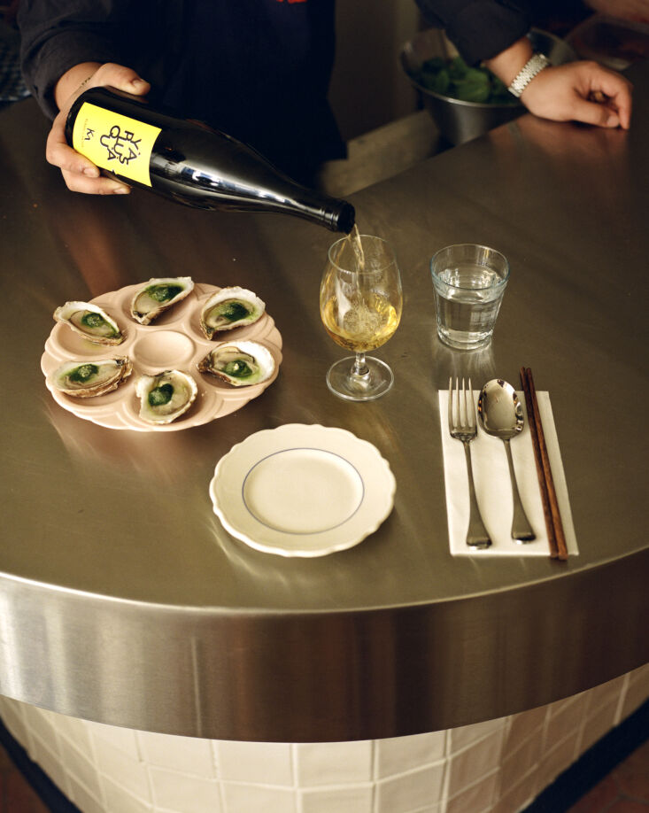 Close-up of the bar base featuring hand-laid white square tiles with a stainless steel top.