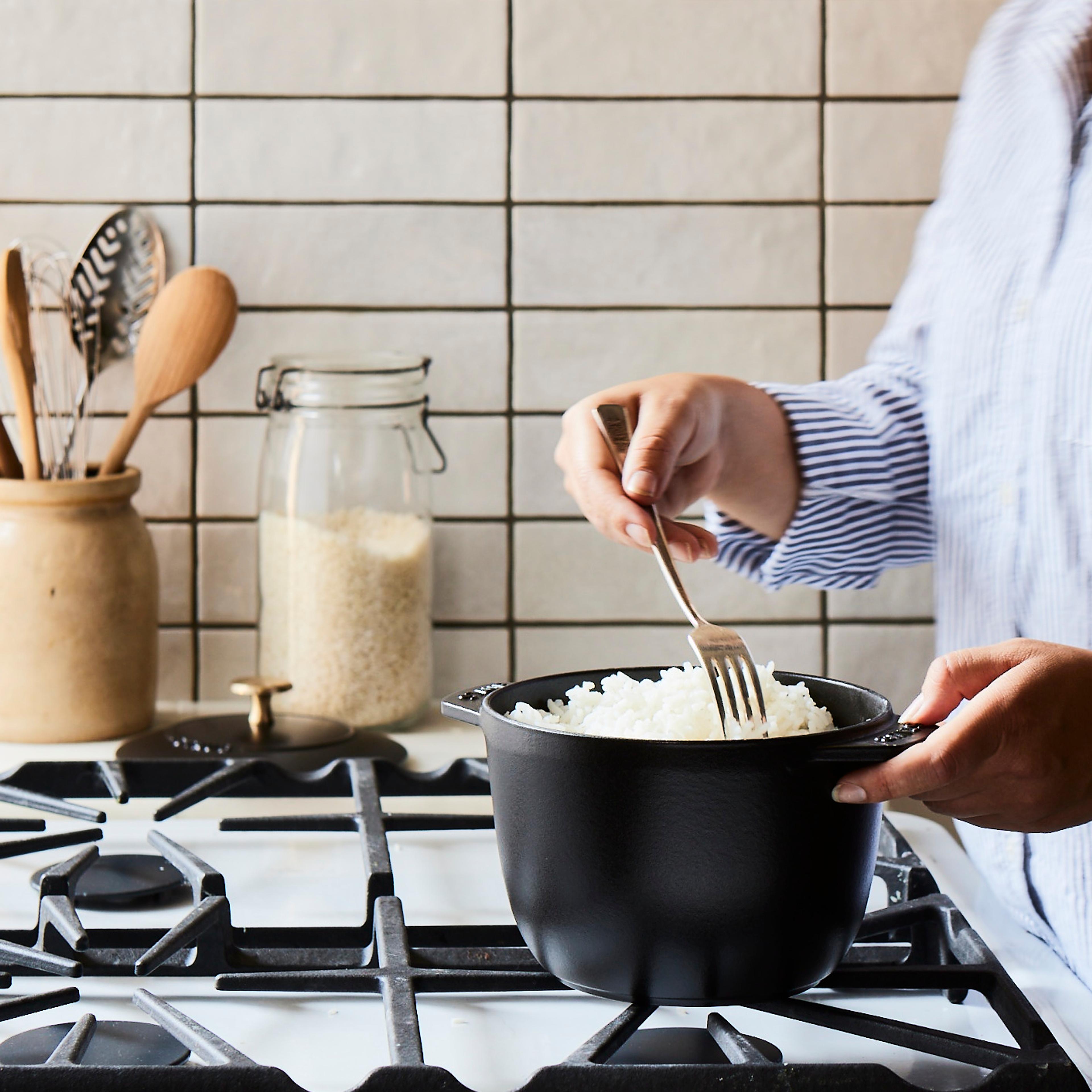 Day-old white rice in a small pot on a stovetop burner.