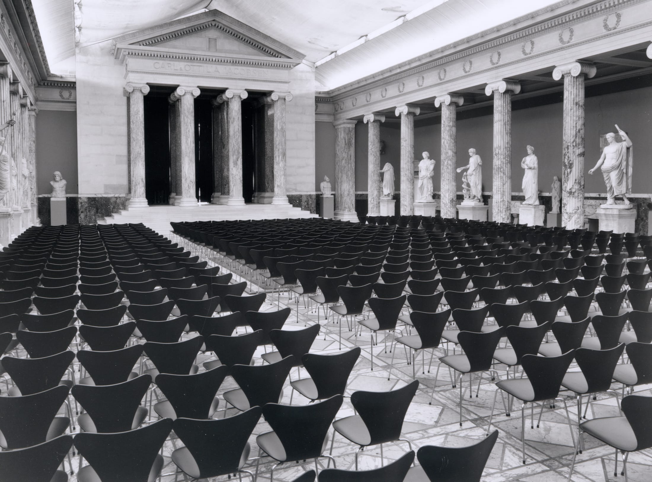 A row of Series 7 chairs arranged in the historic Glyptoteket museum.