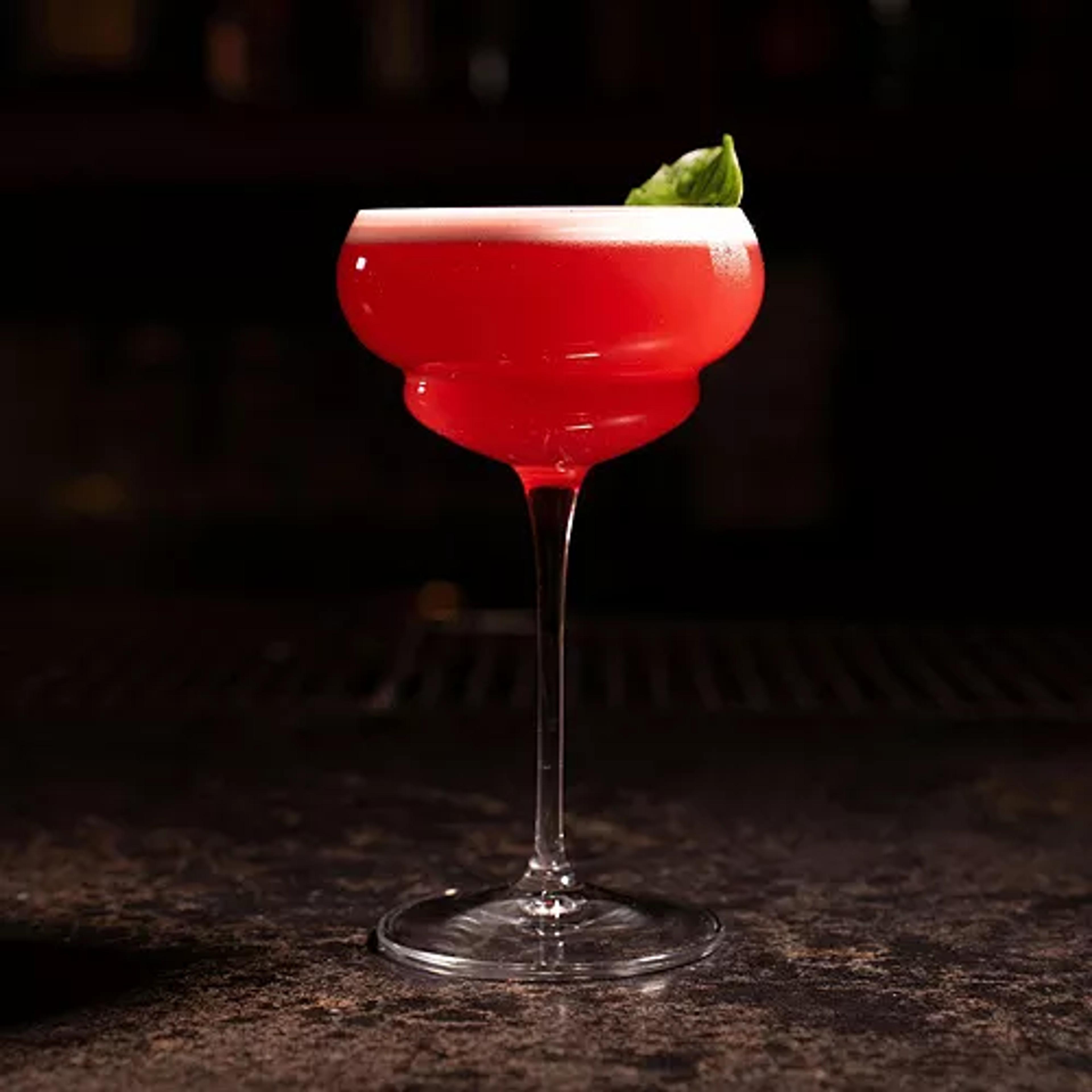 A classic Nick and Nora cocktail glass with a clear drink.