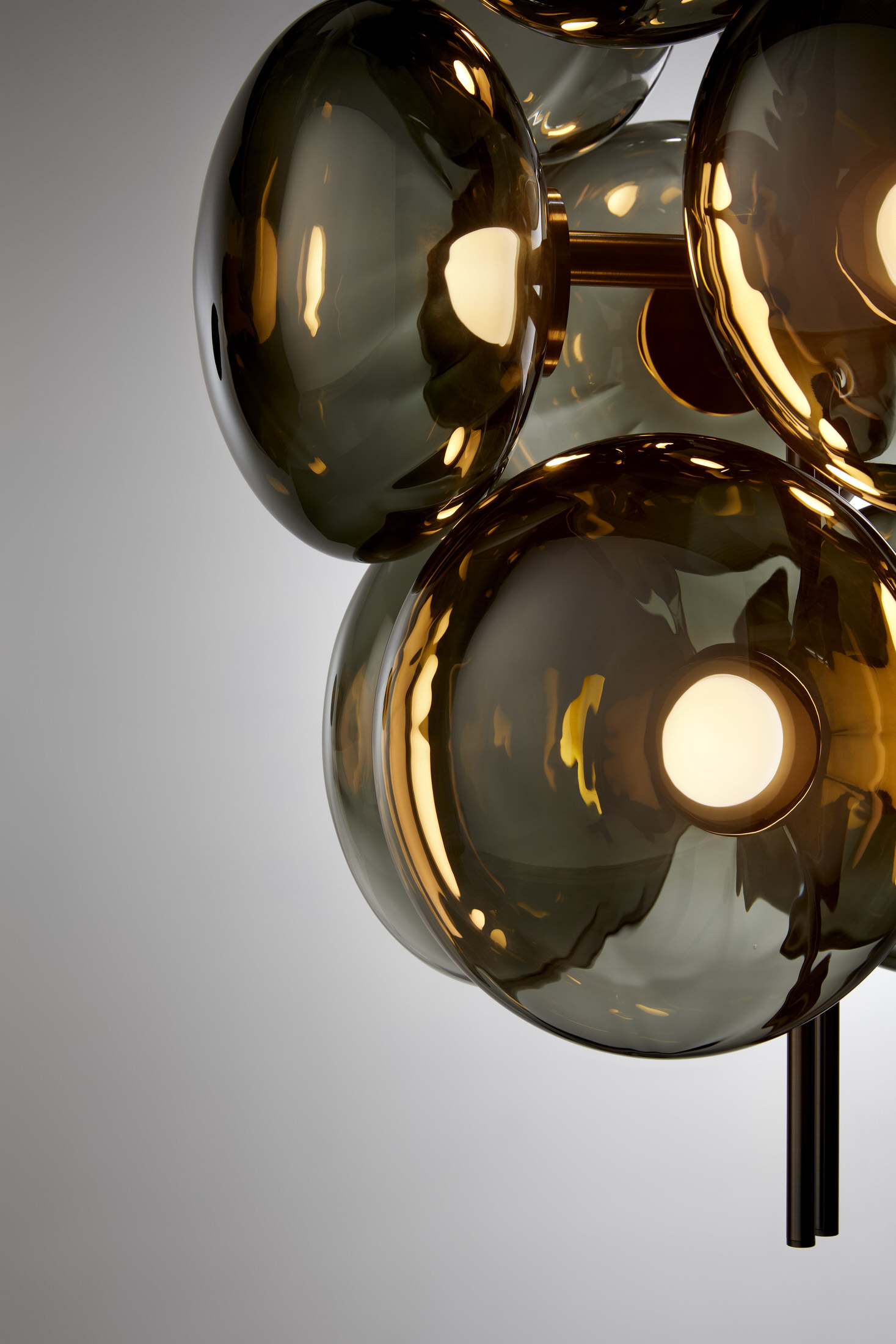 A large-scale modular Aeris chandelier featuring mouth-blown glass spheres and brass bars.