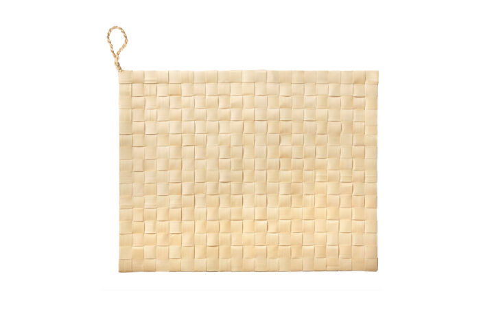 Circular woven placemats made from dried palmyra leaves with small hanging loops.