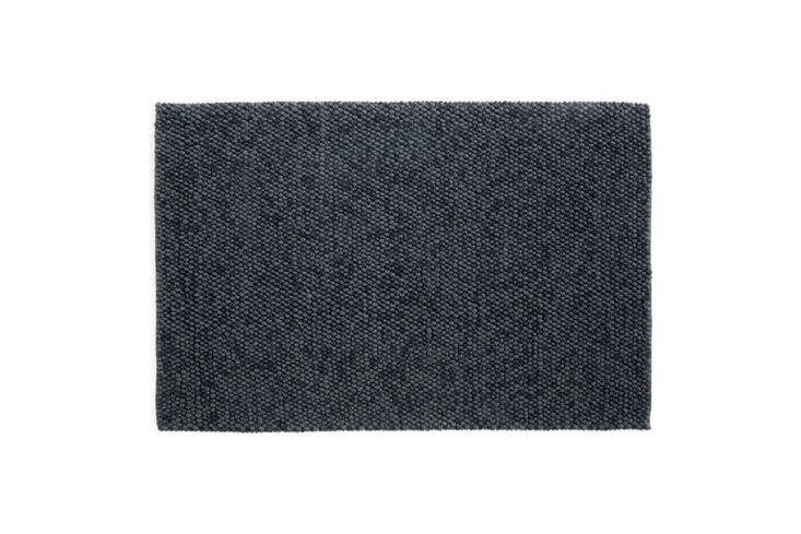 A close-up of a dark grey Hay Peas Carpet showing its pebbled wool texture.