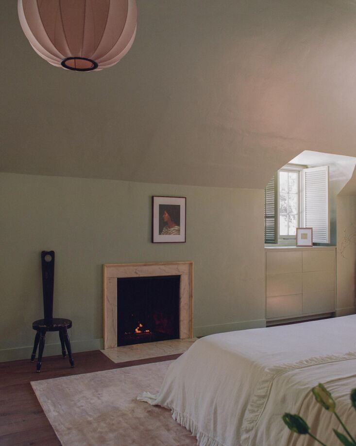 A fireplace with a marble surround in a bedroom setting.