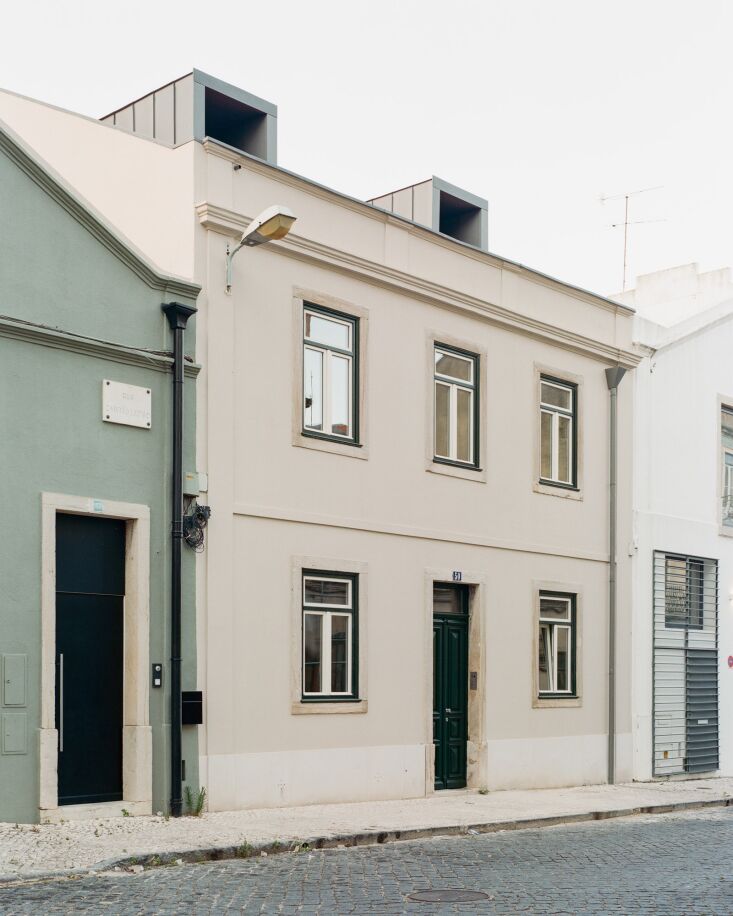 The traditional white Portuguese townhouse facade facing the street in Marvila, Lisbon.