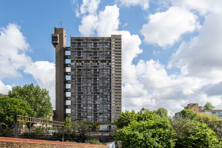 The iconic Trellick Tower in London showing its separate elevator tower and connecting bridges.