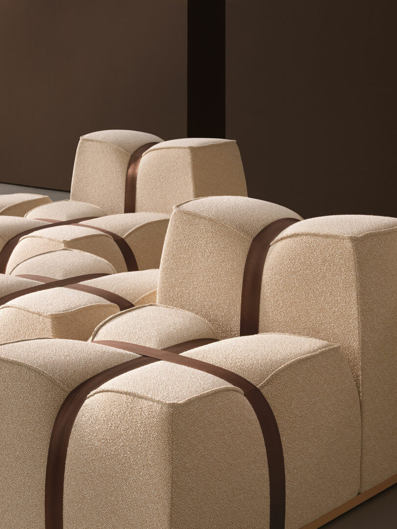 Top-down view of beige upholstered seating blocks arranged in a grid with dark brown straps.