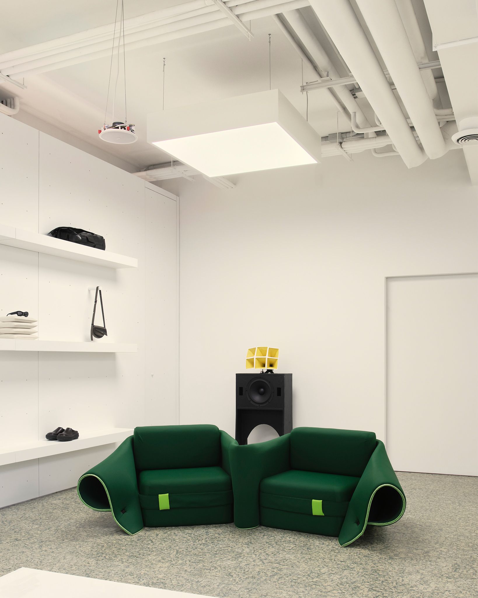 Linear retail racks and geometric architectural details inside the Sunnei store.