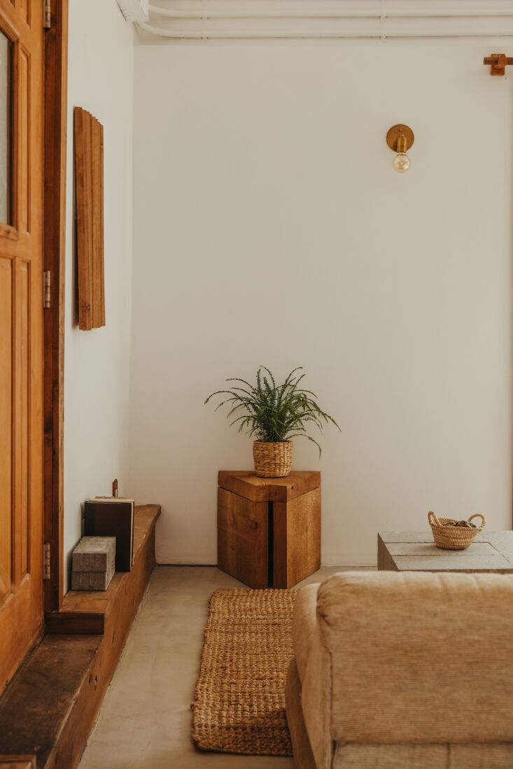 Living room featuring an earthy-toned sectional sofa and cedar wall sculpture.