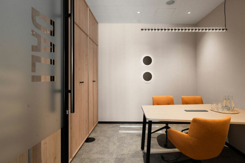 A small meeting room named 'Dali' with orange chairs and a circular wall accent.