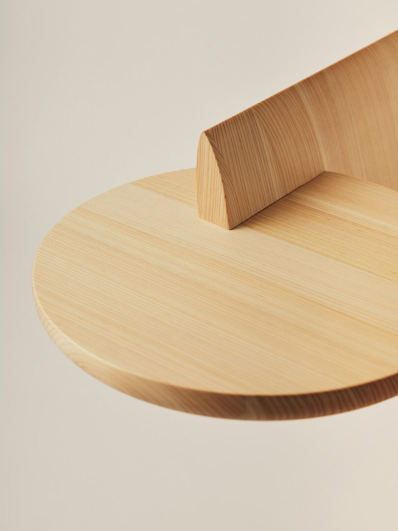 Close-up of the smooth wood grain and curved edge of the Bookmarker table's circular shelf.