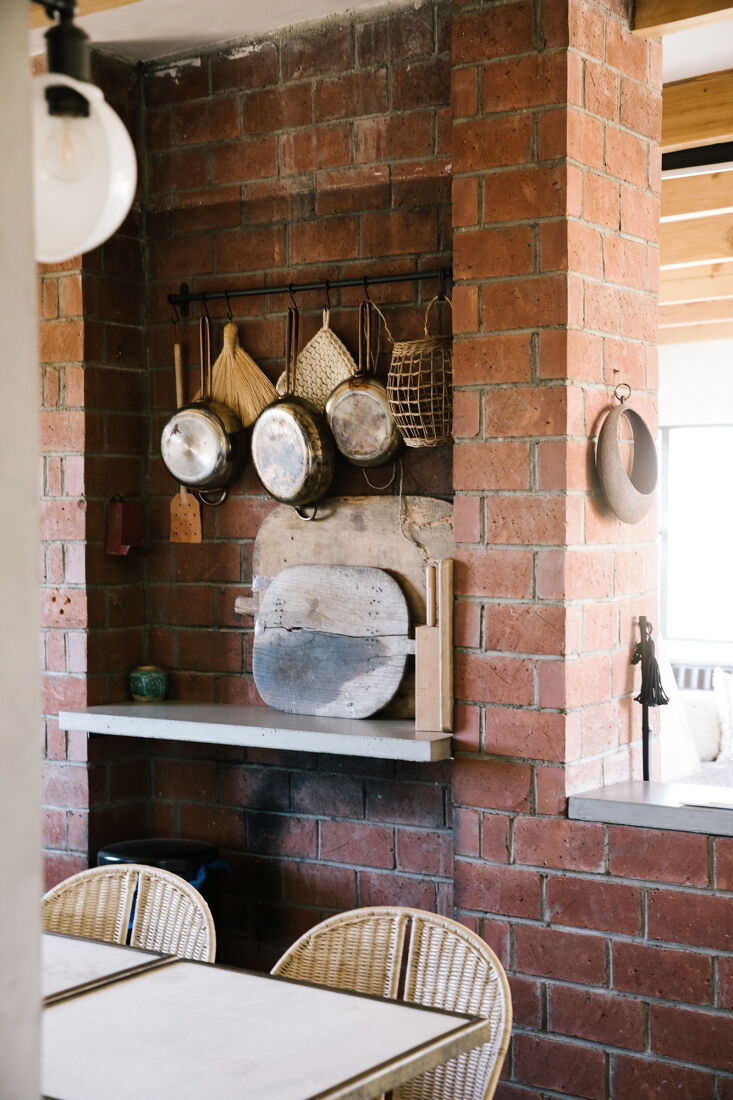 An original brick fireplace integrated with modern concrete countertops in a desert home.