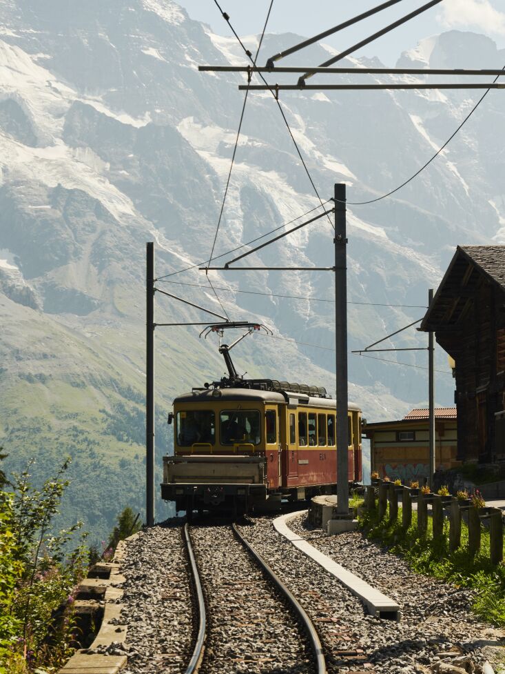 A cable car gondola ascending towards the mountain village of Mürren.