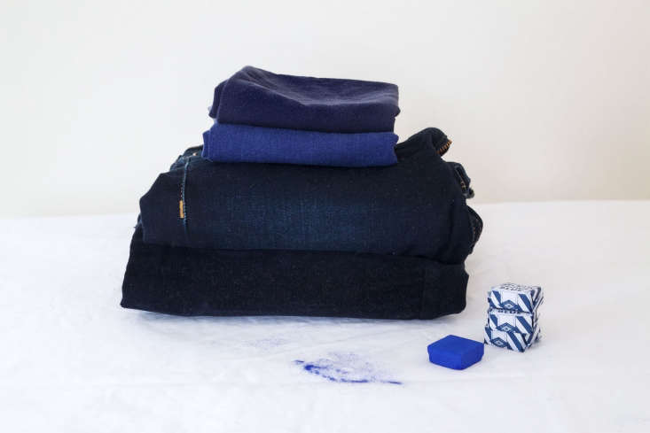 A concentrated blue laundry solution being used on dark blue fabric.