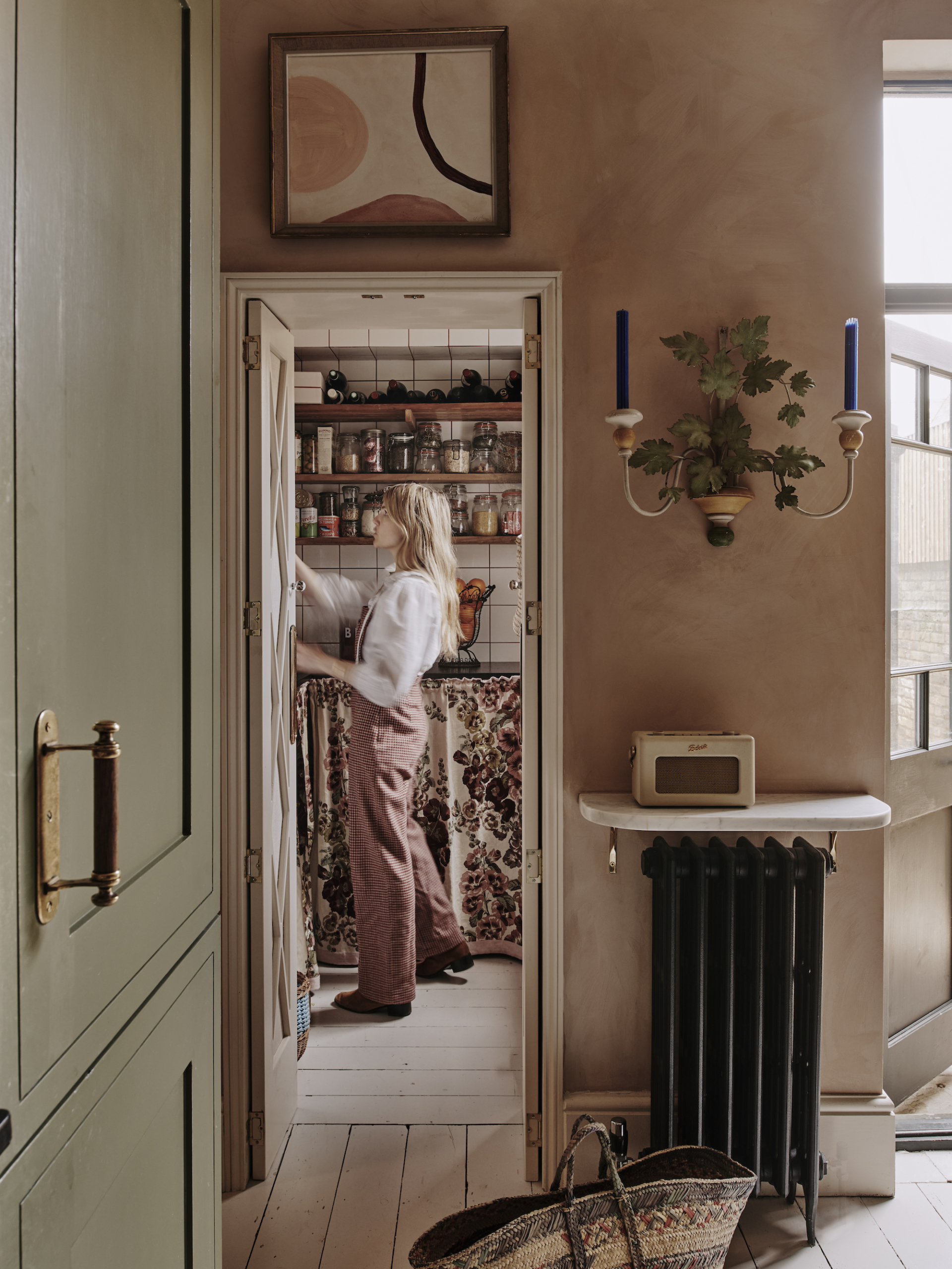 Interior view of a larder with vintage-inspired shelving, colorful grout, and artisanal ceramic jars.