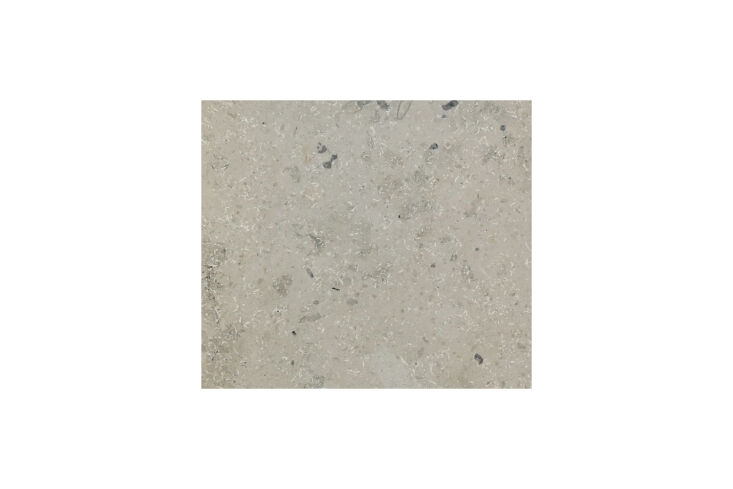 Countertop detail showing Jura Gray limestone with visible fossils paired with bamboo cabinetry.