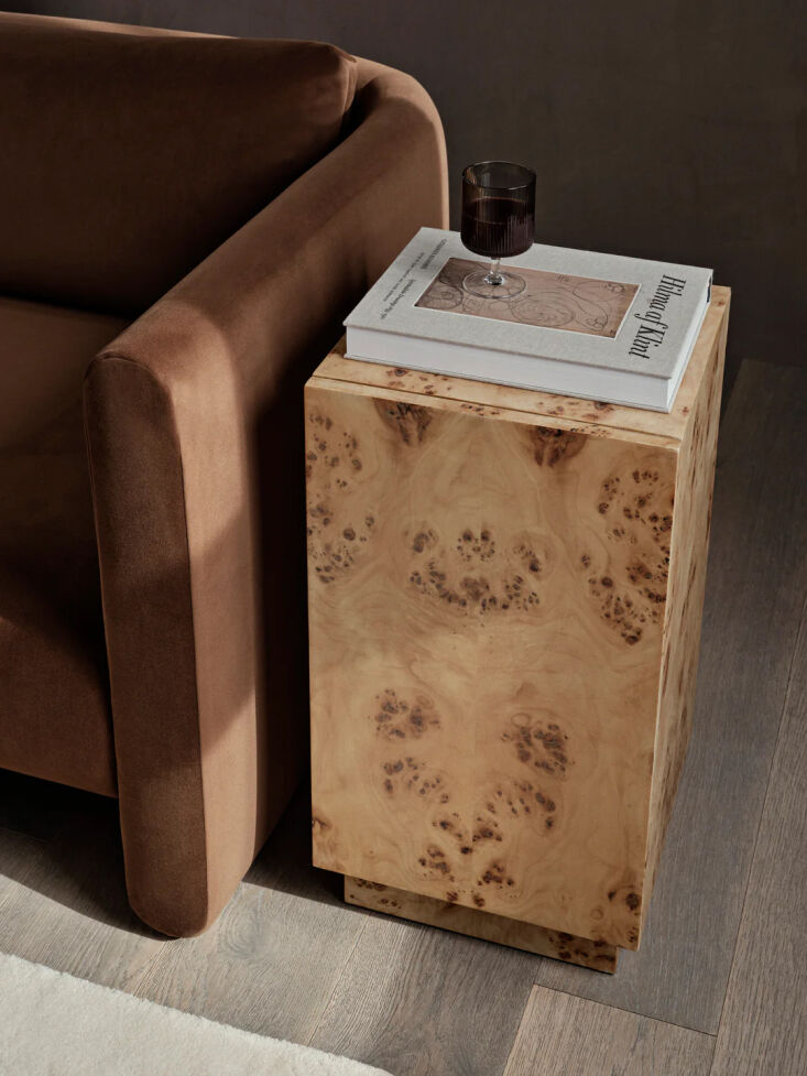 A cube-shaped burl wood side table by Ferm Living that functions as a storage pedestal.