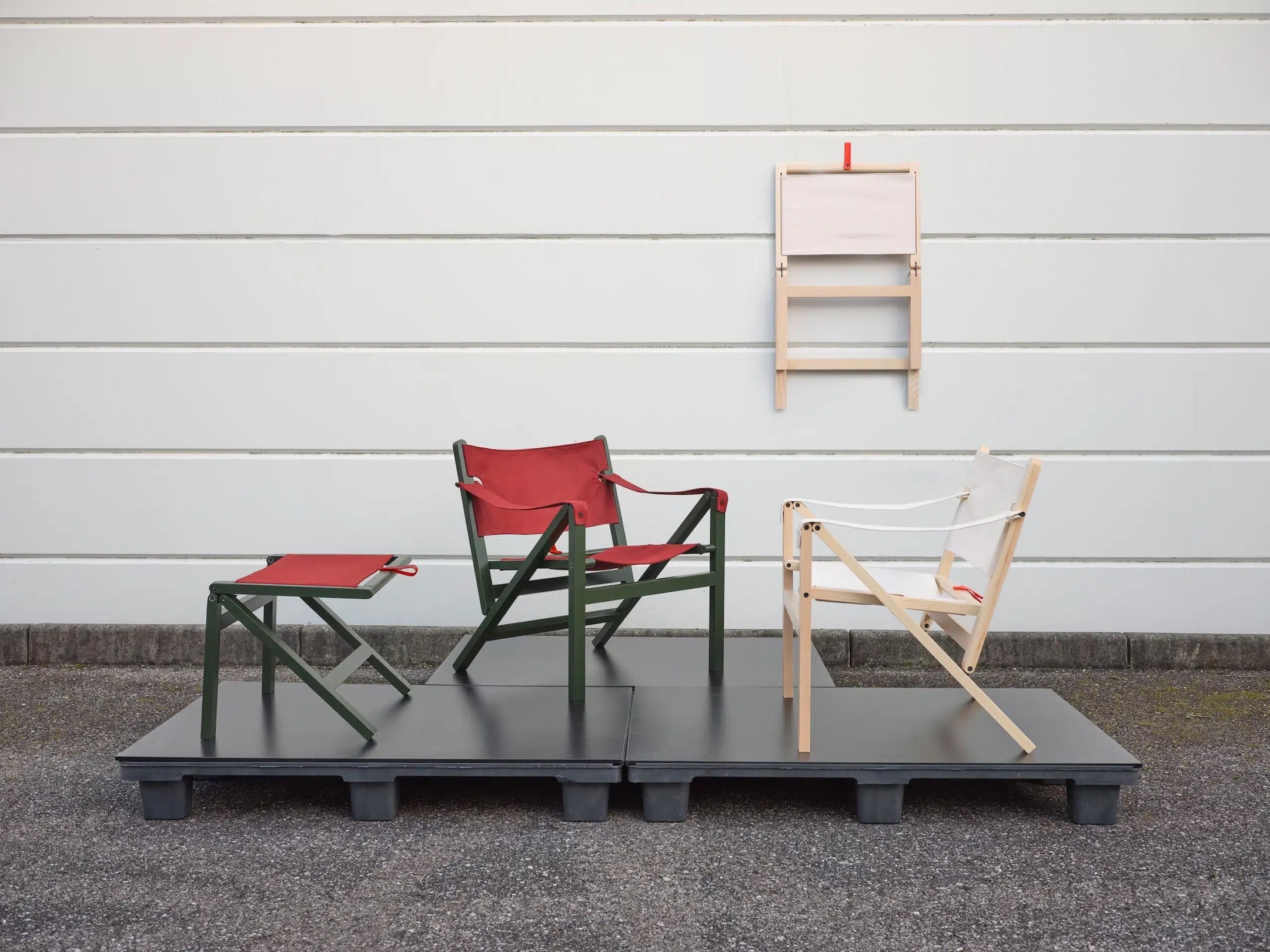 Italian folding chairs from the Mehari collection folded flat and hung from loops on a wall.