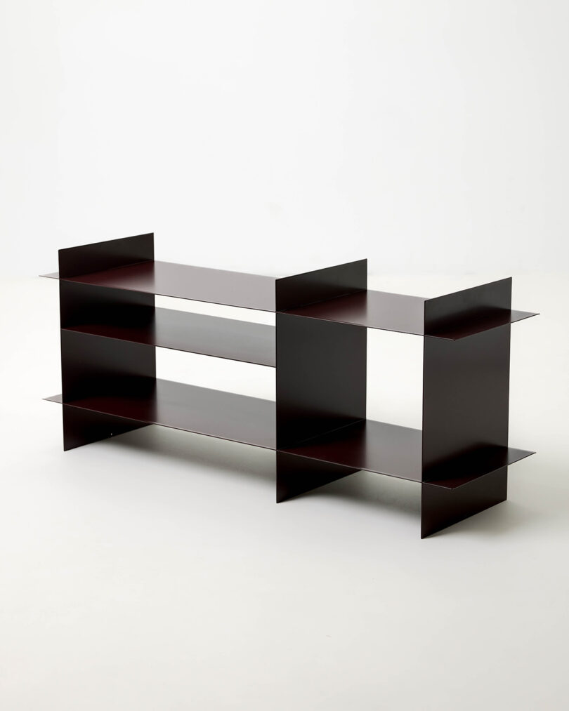 A minimalist dark brown three-tier bookshelf with a thin steel frame against a white background.