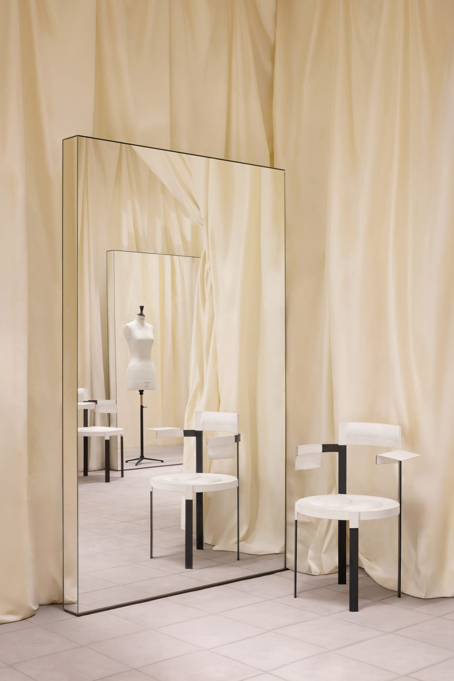 A high-shine pink vinyl sofa by Max Lamb set against a raw concrete wall in the Paris showroom.
