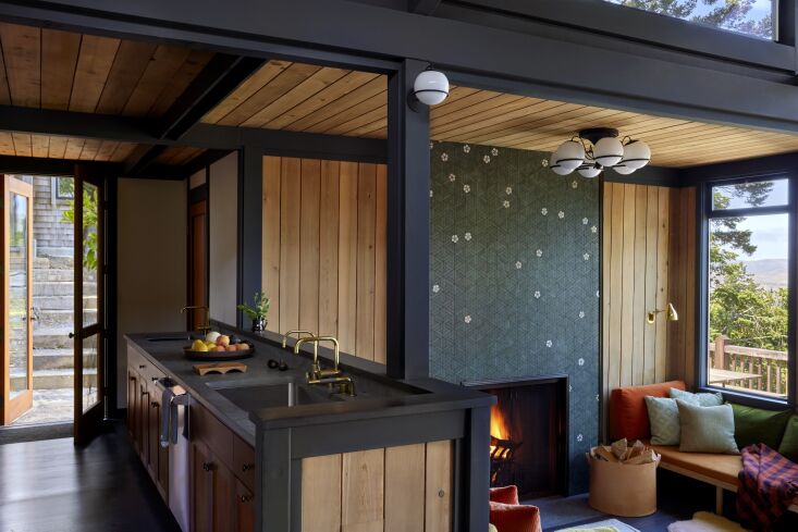 Modern kitchen with Fossil Green Limestone countertops and brass fixtures.