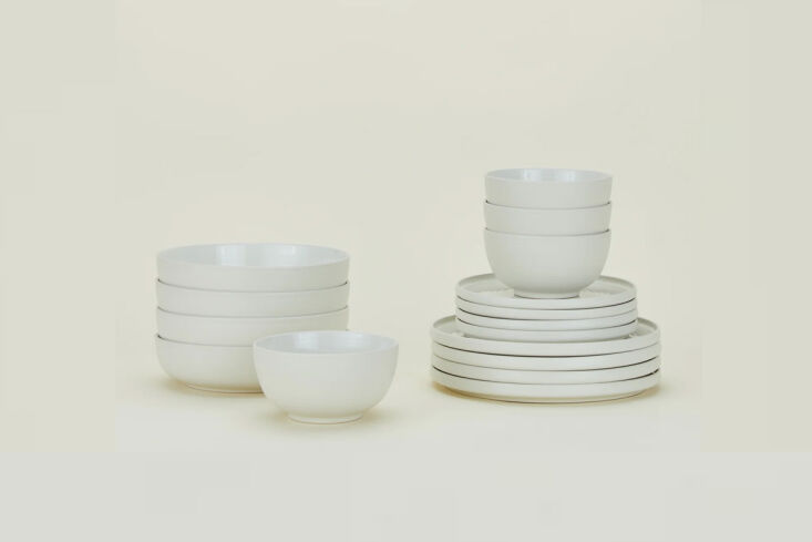 Minimalist blue-toned Hawkins New York Essential dinnerware set on a plain background.