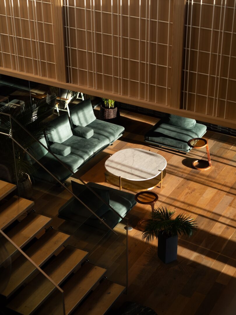 Modern lounge area at The Magarigawa Club featuring green velvet sofas and sleek wooden floors.